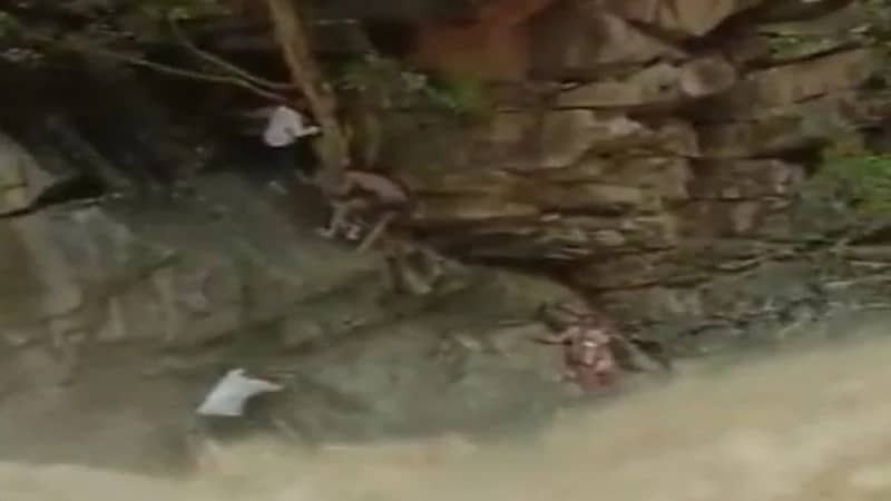 شاهد.. لحظة إنقاذ سيدة محاصرة مع طفلها بسبب تدفق شلالات 