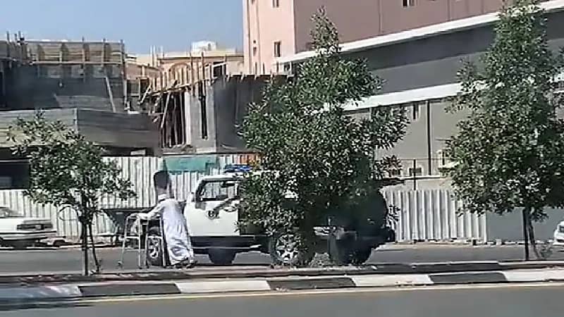 شاهد .. رجل أمن يوقف الطريق لمساعدة مسن على العبور